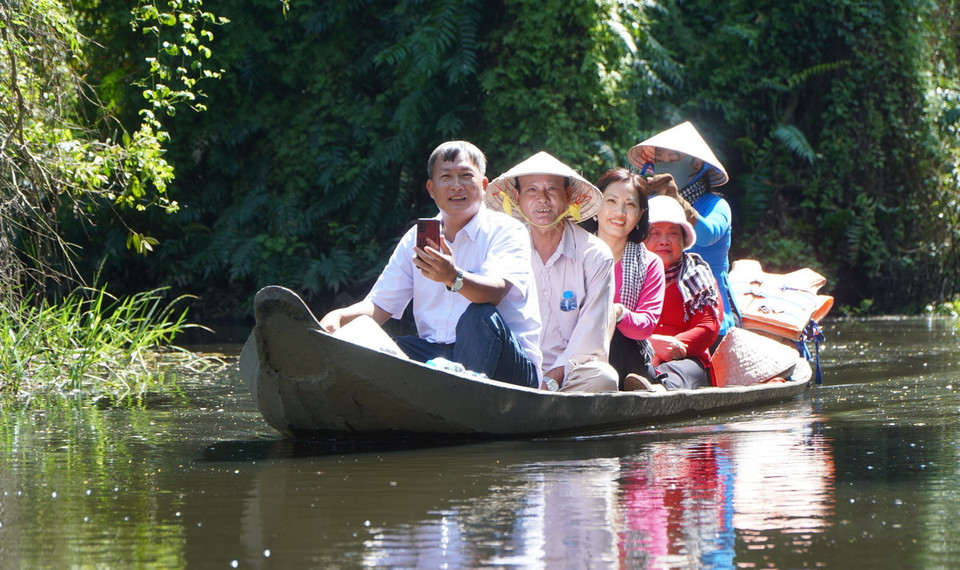 Khách du lịch tham quan Rừng tràm Gáo Giồng bằng xuồng trên kênh. (Ảnh: Nhựt An/TTXVN)
