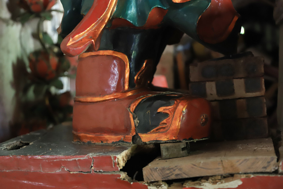 Trải qua nhiều trận mưa bão, tấm kê chân tượng đã bị hỏng, nhà chùa phải chắp vá và dùng gạch để giữ cân bằng cho tượng. (Ảnh: Hoài Nam/Vietnam+)