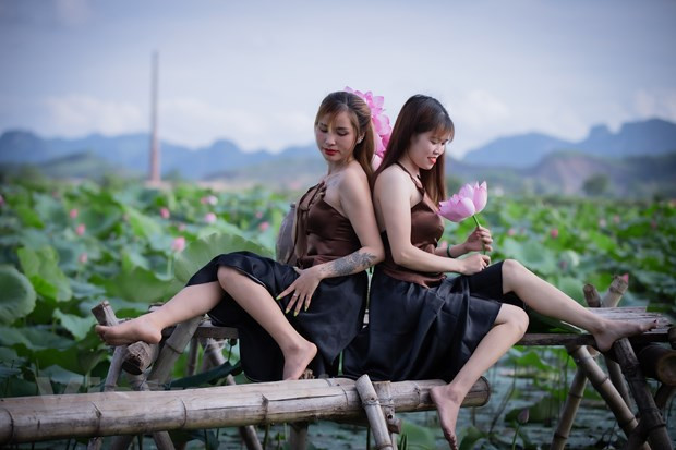 Phái đẹp tranh thủ mùa sen nở rộ đến đây vừa ngắm hoa vừa lưu giữ lại cho mình những bức ảnh tuyệt đẹp. Hai bạn Hà và Thương đến từ Hòa Bình chia sẻ: ‘Lúc đầu chúng tôi định đi chơi thôi nhưng qua đây thấy sen đẹp quá không cưỡng lại được mà phải dừng chân để có những tấm hình ưng ý nhất với loài hoa này.’ (Ảnh: Hoài Nam/Vietnam+)