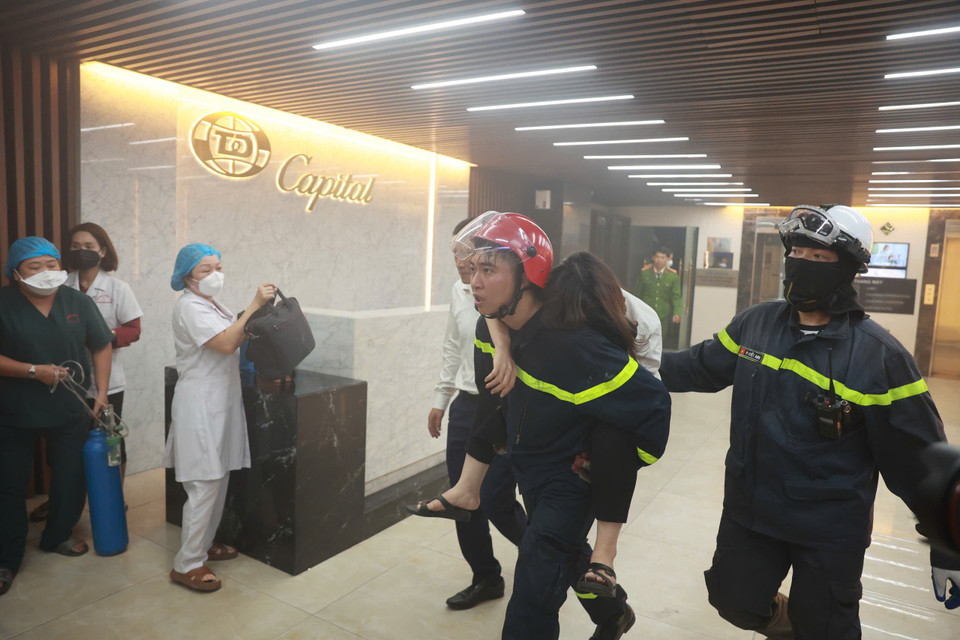 Nạn nhân trên tầng 20 của toà Capital Tower bị ngất được lực lượng chức năng giải cứu (Ảnh: Hoài Nam/Vietnam+)