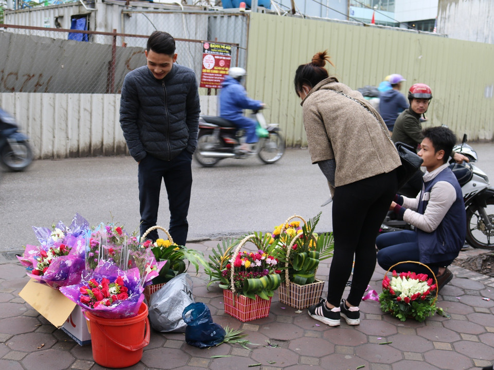 Nhiều bạn sinh viên bán hoa làm thêm dịp 8/3 tại các cổng trường đại học. (Ảnh: Nam Giang/Vietnam+)