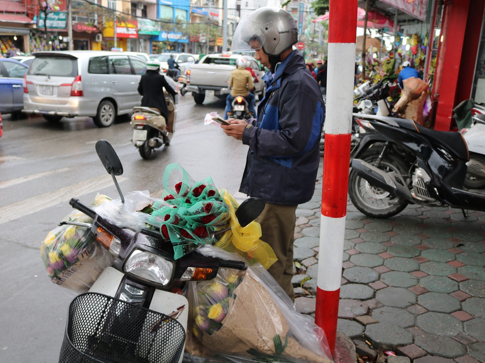 Các shipper bận rộn giao hoa ngày 8/3. (Ảnh: Nam Giang/Vietnam+)