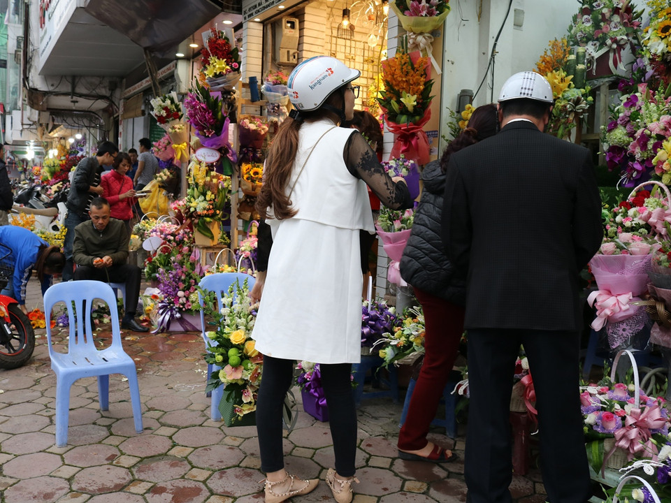 Nhiều phụ huynh mua hoa tặng các cô giáo nhân ngày 8/3. (Ảnh: Nam Giang/Vietnam+)