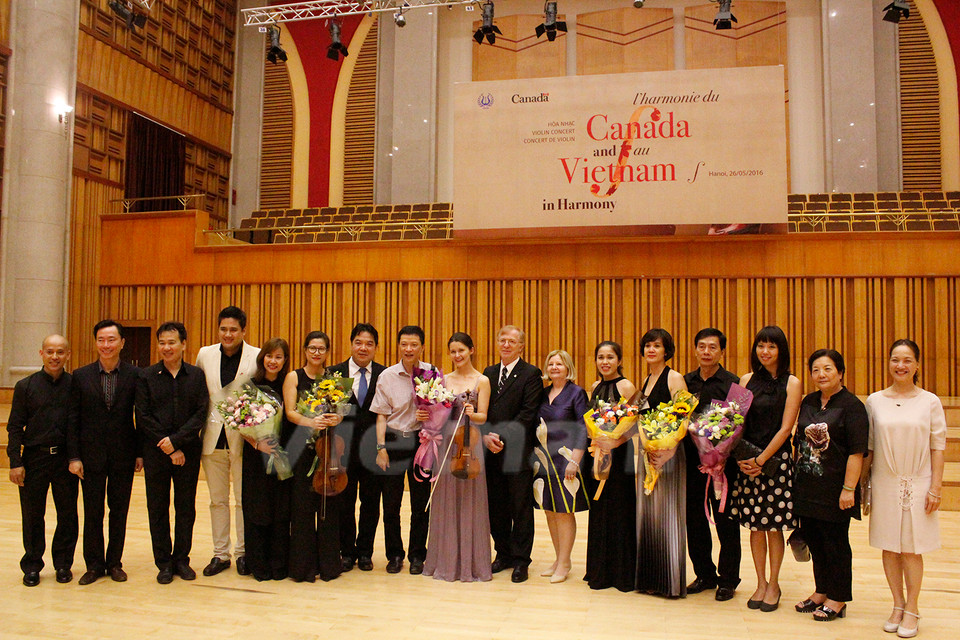 Dàn nghệ sỹ cùng những người trong ban tổ chức, các vị khách quý nán lại chụp ảnh sau đêm diễn. (Ảnh: Hữu Đức/Vietnam+)