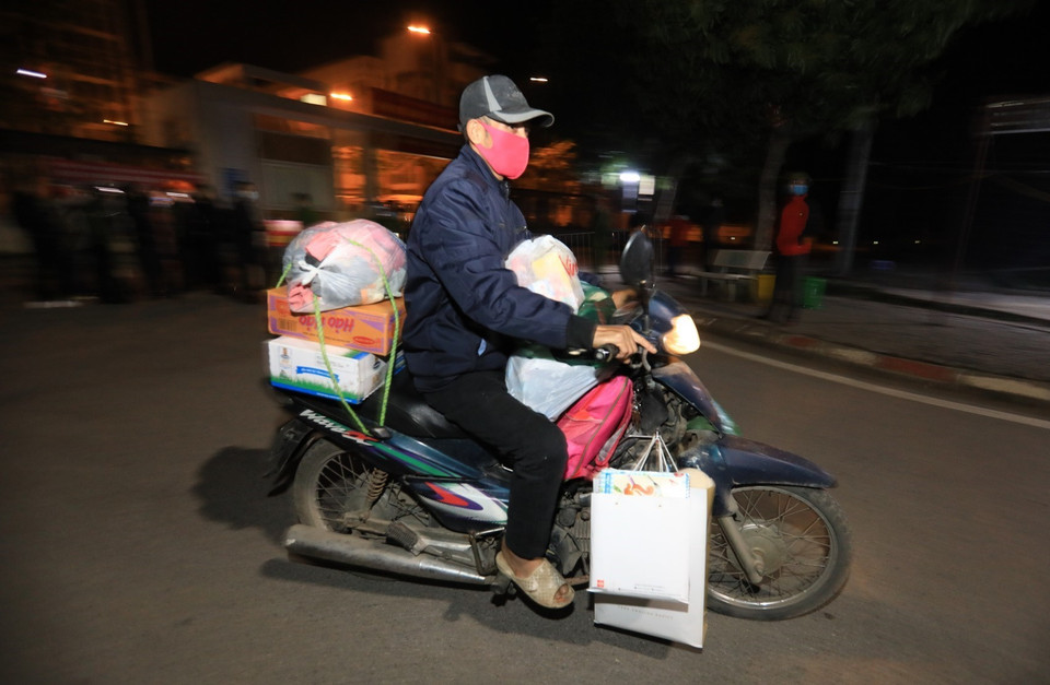 Người nhà học sinh chuyển đồ dùng cá nhân về nhà. (Ảnh: Thành Đạt/TTXVN)