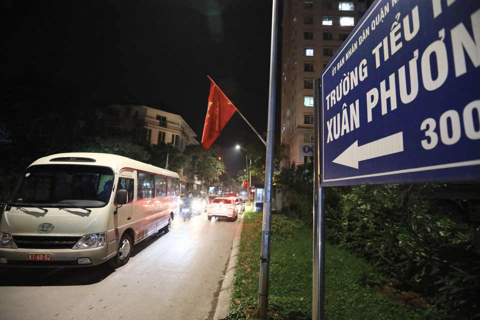 Xe đưa 28 học sinh và phụ huynh trường Tiểu học Xuân Phương ra khỏi khu vực cách ly đề về nhà và tiếp tục cách ly tại nhà, đêm 29 Tết Tân Sửu. (Ảnh: Thành Đạt/TTXVN)