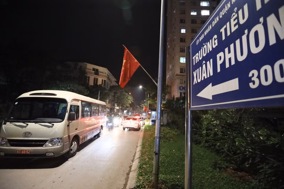 Xe đưa 28 học sinh và phụ huynh trường Tiểu học Xuân Phương ra khỏi khu vực cách ly đề về nhà và tiếp tục cách ly tại nhà, đêm 29 Tết Tân Sửu. (Ảnh: Thành Đạt/TTXVN)
