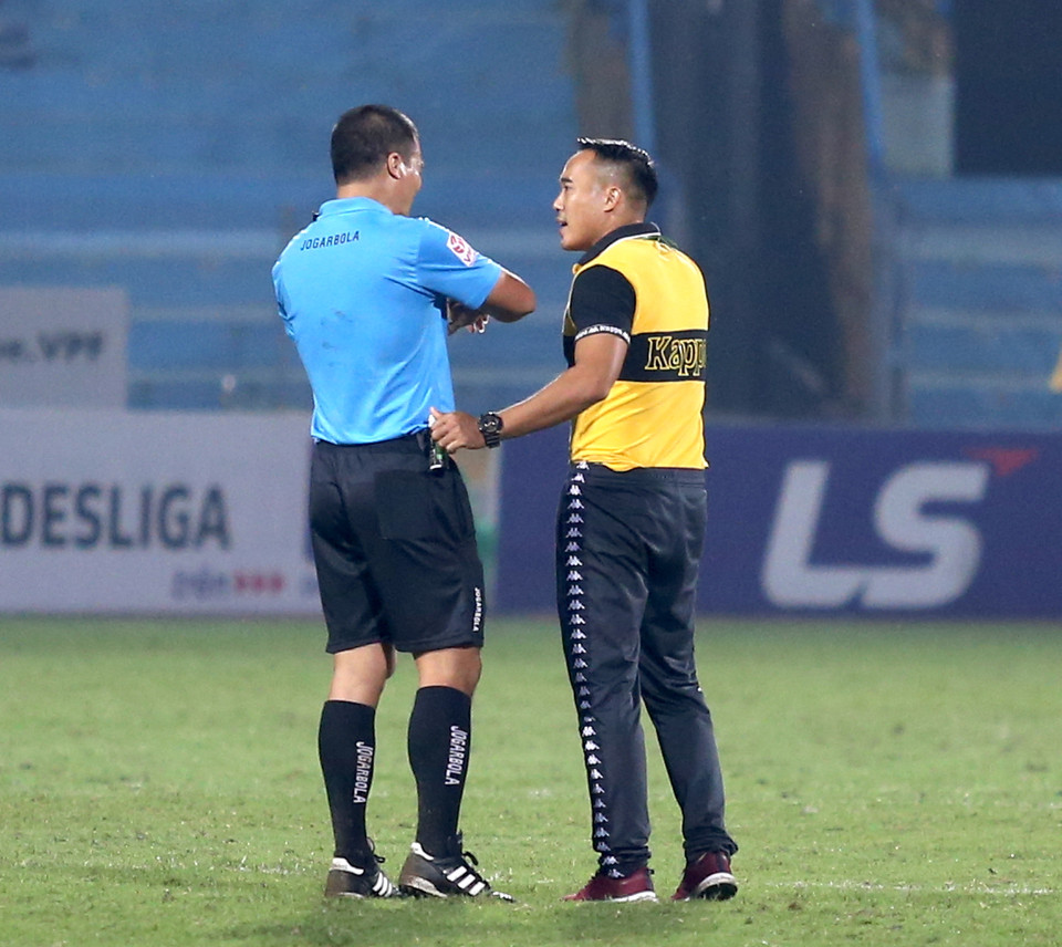 Trợ lý huấn luyện viên Nguyễn Công Tuấn lao ngay vào sân sân để phàn nàn với trọng tài chính Nguyễn Đình Thái ngay sau tiếng còi kết thúc hiệp một trận Hà Nội-Sài Gòn FC ở vòng 6 giai đoạn hai V-League 2020 tối 4/11 trên sân nhà Hàng Đẫy. (Ảnh: Hiển Nguyễn/Vietnam+)
