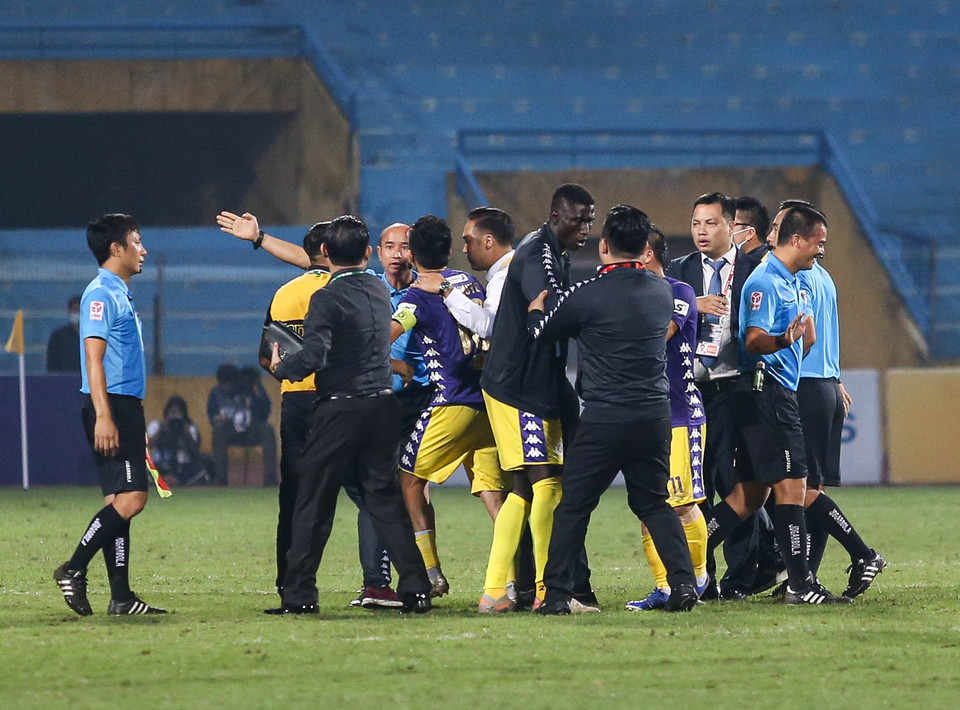 Ban huấn luyện, nhiều cầu thủ Hà Nội FC cũng lần lượt lao vào sân để phân bua với trọng tài chính. (Ảnh: Hiển Nguyễn/Vietnam+)