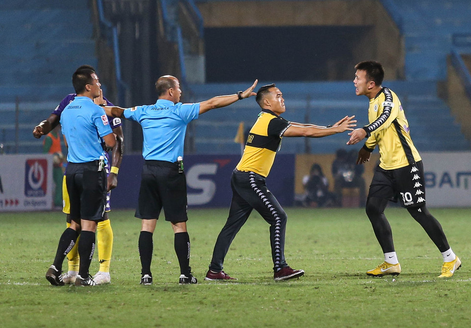 Ông Tuấn muốn góp ý, phản biện sau 45 phút đầu tiên Hà Nội FC liên tục gặp bất lợi vì quyết định của trọng tài chính. Tuy nhiên, hành động này bất ngờ kéo theo sự căng thẳng. (Ảnh: Hiển Nguyễn/Vietnam+)