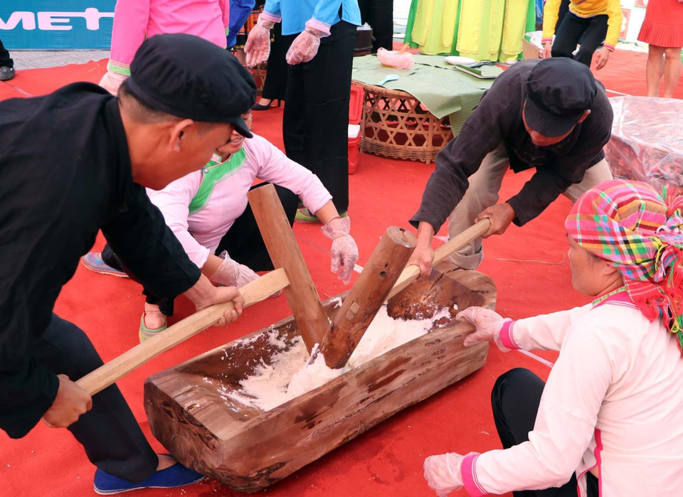 Thành viên của các đội khẩn trương giã bánh dày làm sao với thời gian nhanh nhất để có được nguyên liệu vừa mịn mà vẫn còn nóng dẻo thành phần chính làm ra những chiếc bánh dày mịn, bóng, thơm ngon đẹp mắt. (Ảnh: Quý Trung/TTXVN)