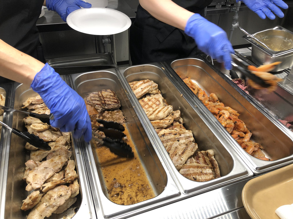 Toàn bộ các thành viên của Đoàn Thể thao Việt Nam phải thực hiện việc sát khuẩn, đeo khẩu trang, dùng găng tay để lấy thức ăn, tránh chạm tay vào các đồ dùng trong nhà ăn. (Ảnh: Thu Sâm) 