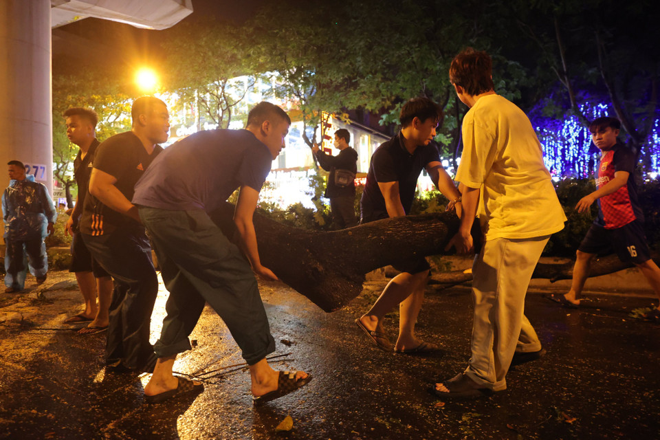 Người dân cùng lực lượng chức năng cùng nhau nỗ lực giải quyết hậu quả vì mưa lớn. (Ảnh: Minh Sơn/Vietnam+) 