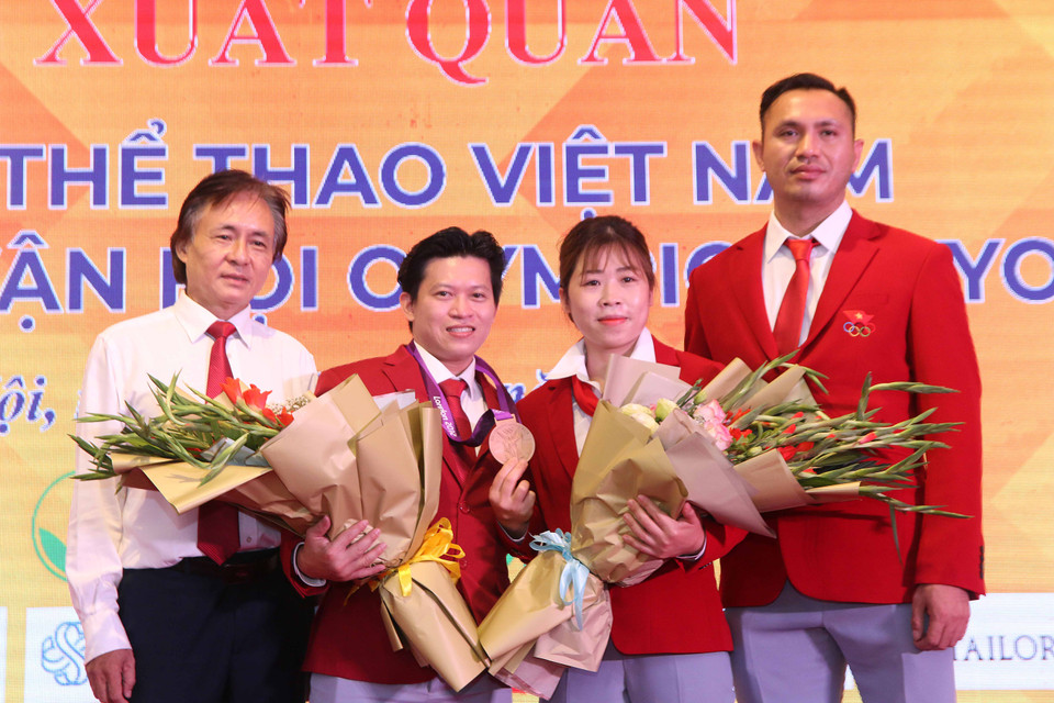 Tại Lễ xuất quân, Ban tổ chức cũng trang trọng tiến hành lễ trao tấm huy chương đồng cử tạ Olympic London 2012 hạng 56 kg và tiền thưởng cho vận động viên Trần Lê Quốc Toàn. Trước đó, Ủy ban Olympic quốc tế IOC xác nhận vận động viên Valentin Hristov (Azerbajan) bị tước huy chương do có kết quả xét nghiệm doping dương tính và trao cho Quốc Toàn. (Ảnh: PV/Vietnam+)