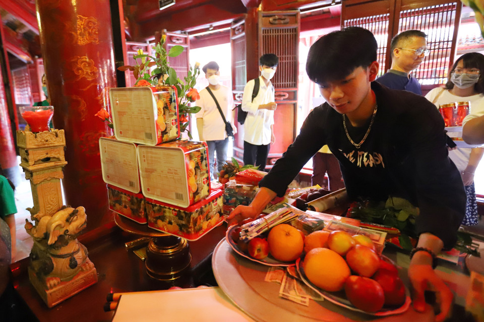 Nhiều học sinh tự đến Văn Miếu dâng lễ và cầu may. Trong ảnh là nhóm học sinh đến từ Ninh Bình chuẩn bị dâng hương, với mong muốn đạt được kết quả tốt nhất trong kỳ thi sắp tới. (Ảnh: Hoài Nam/Vietnam+)