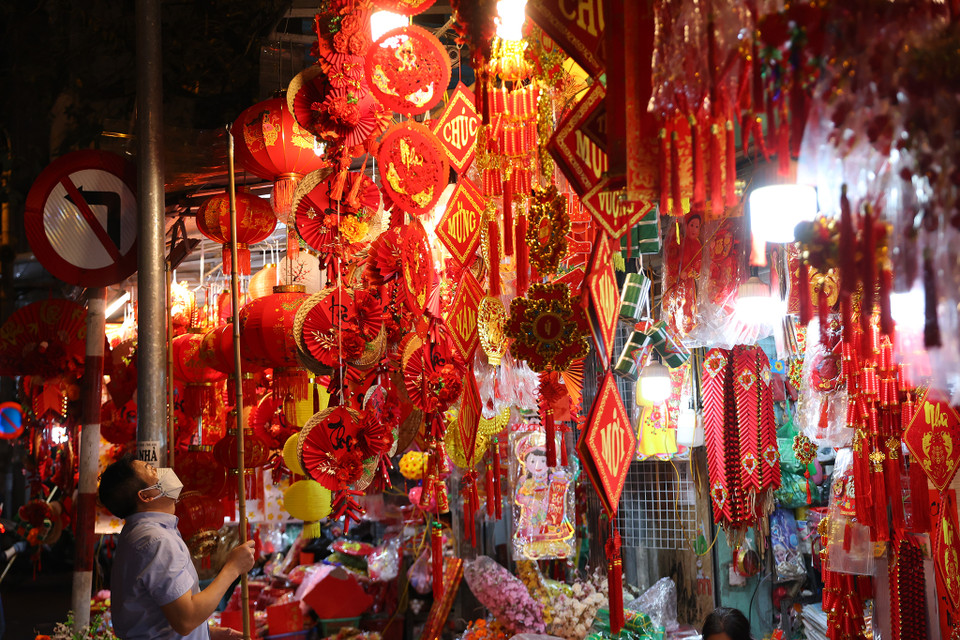 Cũng giống như mọi năm, tại Hàng Mã người tiêu dùng có thể bắt gặp các mặt hàng trang trí truyền thống như đèn lồng, dây cá chép, dây trang trí, đôi câu đối đỏ, mô hình bánh chưng xanh, những chiếc phong bao lì xì. (Ảnh: Hoài Nam/Vietnam+)