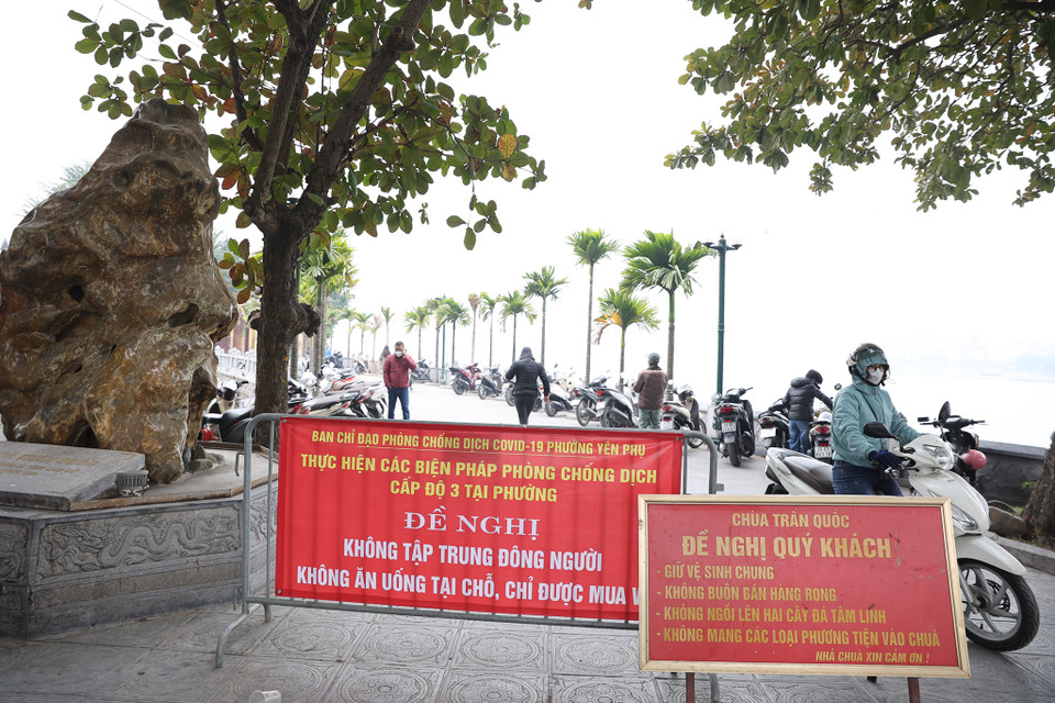 Tại địa điểm chùa Trấn Quốc, cơ sở vẫn mở cửa đón khách. Ban chỉ đạo phòng chống dịch phường Yên Phụ đã dựng biển báo nhắc nhở người dân không tụ tập quá đông đúc và đảm bảo quy tắc 5K. (Ảnh: Hoài Nam/Vietnam+)