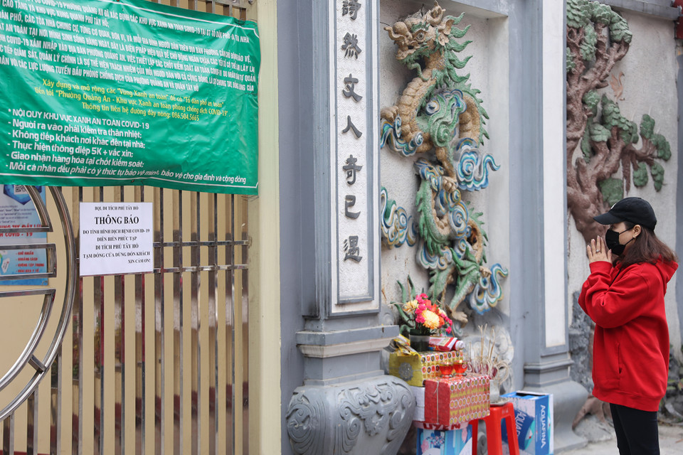 Người dân nghiêm túc thực hiện quy định không tụ tập tại các địa điểm đông đúc mà chỉ đứng từ xa vái vọng. (Ảnh: Hoài Nam/Vietnam+)