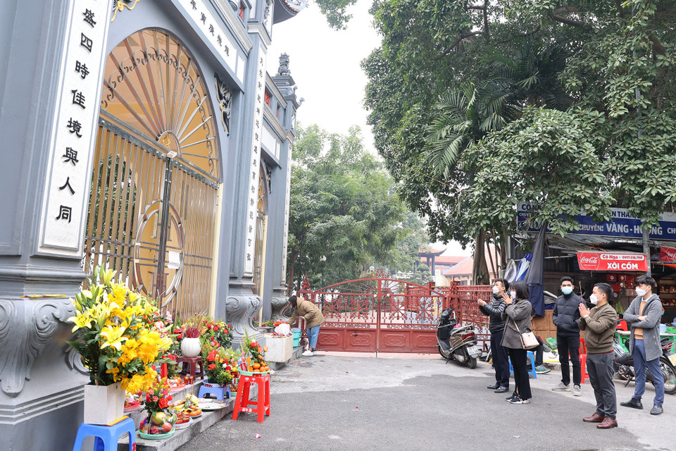 Ghi nhận tại phủ Tây Hồ, chỉ số ít người dân trong khu vực được đến để dâng hương và lễ. Lực lượng chức năng đã dựng rào chắn cấm đường trước đó để tránh tình trạng người dân tụ tập quá đông. (Ảnh: Hoài Nam/Vietnam+)