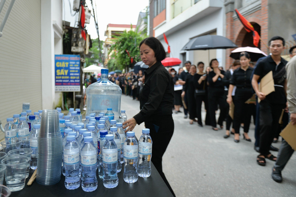 Người dân làng Lại Đà chuẩn bị nước miễn phí phục vụ các đoàn viếng Tổng Bí thư. (Ảnh: Thùy Giang/Vietnam+)