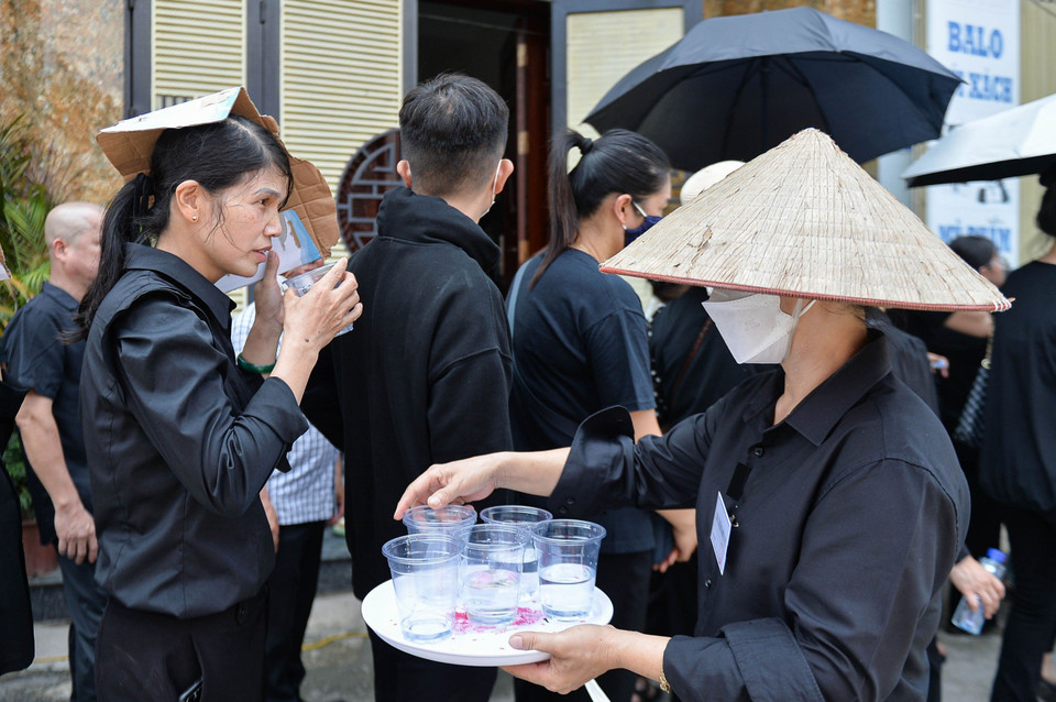 Người dân Lại Đà tiếp nước cho những người dự lễ viếng. (Ảnh: Thùy Giang/Vietnam+)
