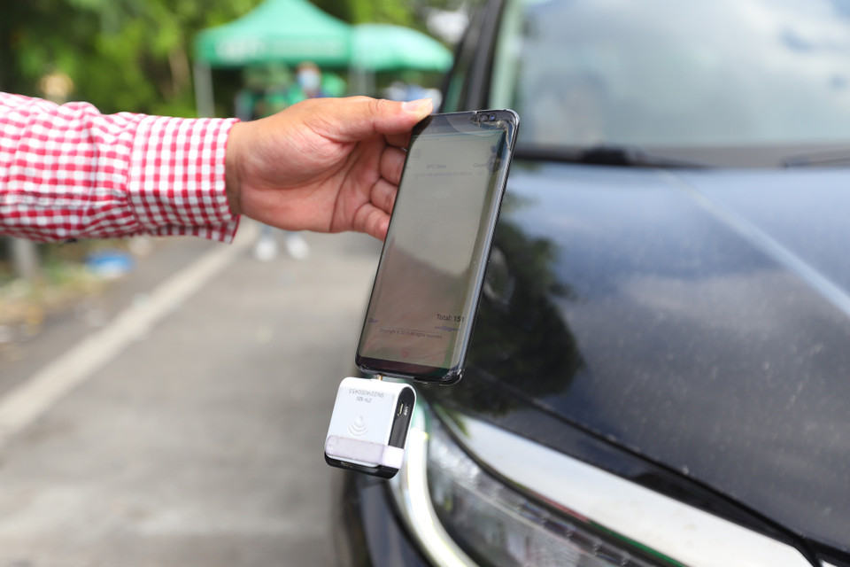 Sau khi dán thẻ, nhân viên sẽ có thiết bị kiểm tra đảm bảo kết nối giữa thẻ VETC trên xe và mã trên hệ thống. (Ảnh: Hoài Nam/Vietnam+)