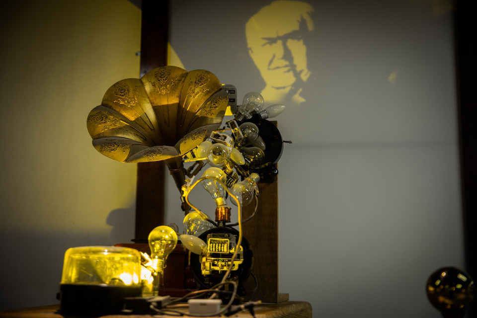 Tác giả sử dụng những phát minh của Edison như bóng đèn sợi đốt, máy hát đĩa quay để làm phần vật thể phía trước. Bức chân dung của nhà bác học Edison sẽ hiện ra khi ánh sáng chiếu vào các phát minh của ông. (Ảnh: Hoài Nam/Vietnam+)