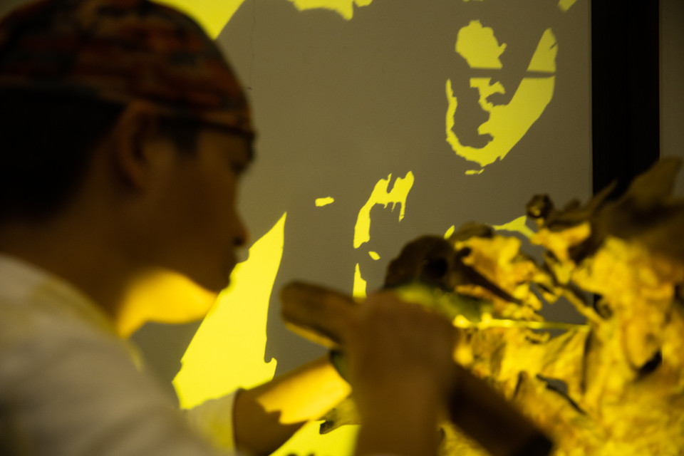 Người ta khó nhận ra một tác phẩm gỗ lũa kỳ dị trước mắt thể hiện điều gì. Khi soi ánh sáng vào mới thấy được kết quả cuối cùng về hình hài của cái bóng. (Ảnh: Hoài Nam/Vietnam+)