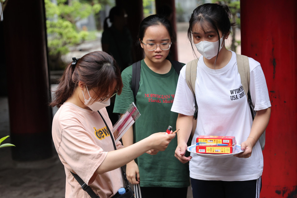 Có những nhóm học sinh tự đến trường Đại học đầu tiên của Việt Nam để dâng lễ, cầu mong thuận lợi, tinh thần minh mẫn nhất khi thi cử. (Ảnh: Hoài Nam/Vietnam+)