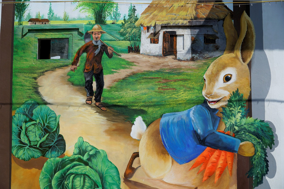 Các sản phẩm nông nghiệp như rau, củ quả gắn liền với công việc hàng ngày của người dân địa phương được thể hiện sinh động trên tường. (Ảnh: Minh Hiếu/Vietnam+)