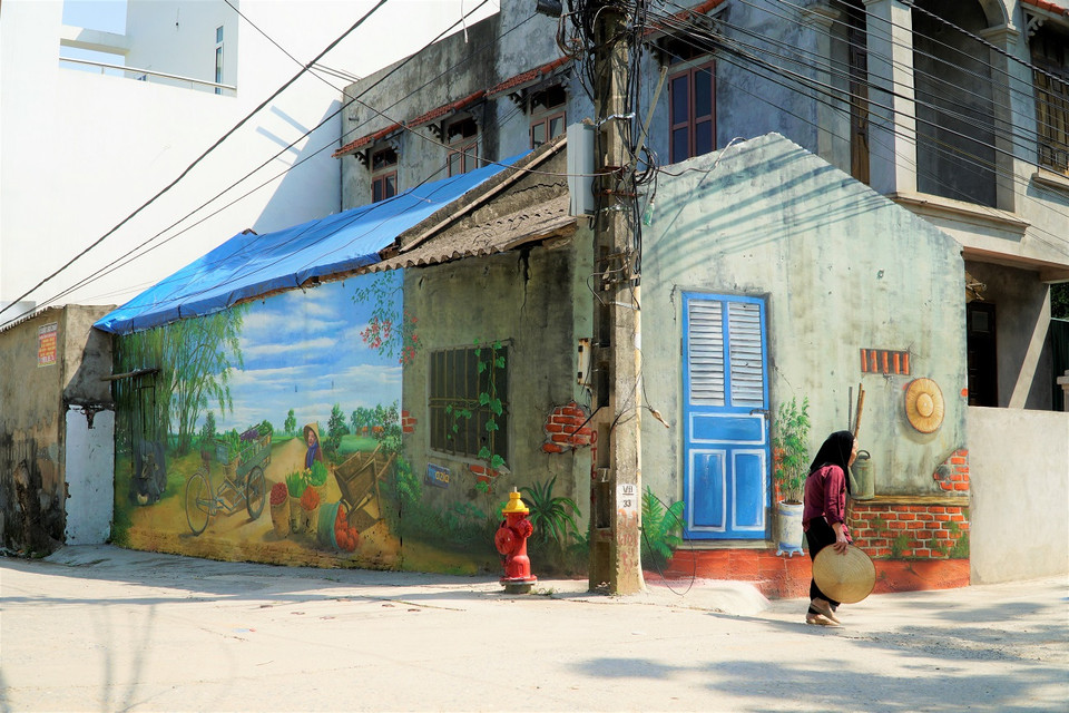 Lấy cảm hứng về một làng quê yên bình, đồng thời gắn với sản phẩm kinh tế chính của ngôi làng là các loại nông sản sạch, toàn bộ 15 bức vẽ đều tái hiện những hình ảnh quen thuộc từ chính đời sống của người nông dân. (Ảnh: Minh Hiếu/Vietnam+)