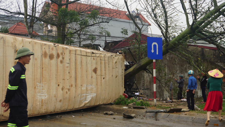 Xe container bị lật nghiêng, nằm chắn ngang làn đường ngược chiều khiến các phương tiện giao thông không thể đi qua làn đường này. (Nguồn: Khiếu Tư/TTXVN)