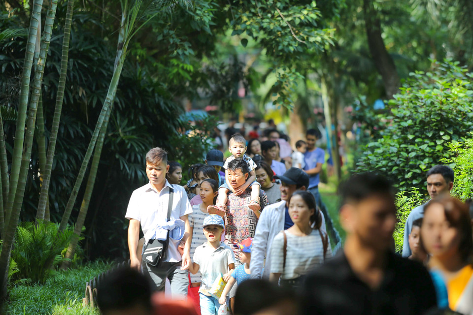 Để có được một ngày vui chơi vui vẻ tại Công viên Thủ Lệ, những ông bố, bà mẹ phải rất vất vả chăm sóc cho con nhỏ. (Ảnh: Vietnam+)