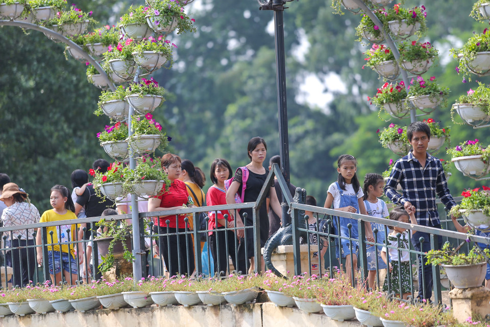Buổi trưa, du khách càng đông đúc. Những chiếc ghế đá, quầy đồ ăn hay thậm chí là bãi cỏ trong công viên trở thành nơi nghỉ ngơi của hàng nghìn du khách. (Ảnh: Vietnam+)