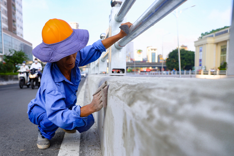 Những hạng mục nhỏ cuối cùng trước khi hoàn thiện cũng được chăm chút kỹ lưỡng, phần bê tông được đánh nhẵn trước khi phun sơn để đảm bảo độ bám dính. (Ảnh: Hoài Nam/Vietnam+)