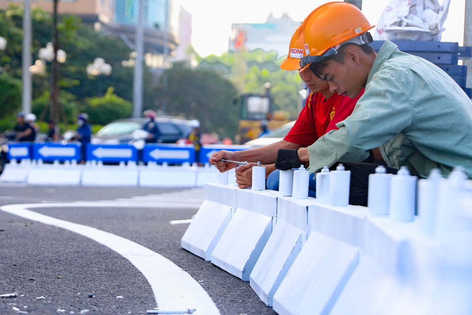 Biển báo, dải phân cách cũng được thi công tỷ mỷ, chính xác. Trong ảnh là dải phân cách đang được lắp trên ngã tư Lê Văn Lương- Khuất Duy Tiến. (Ảnh: Hoài Nam/Vietnam+)