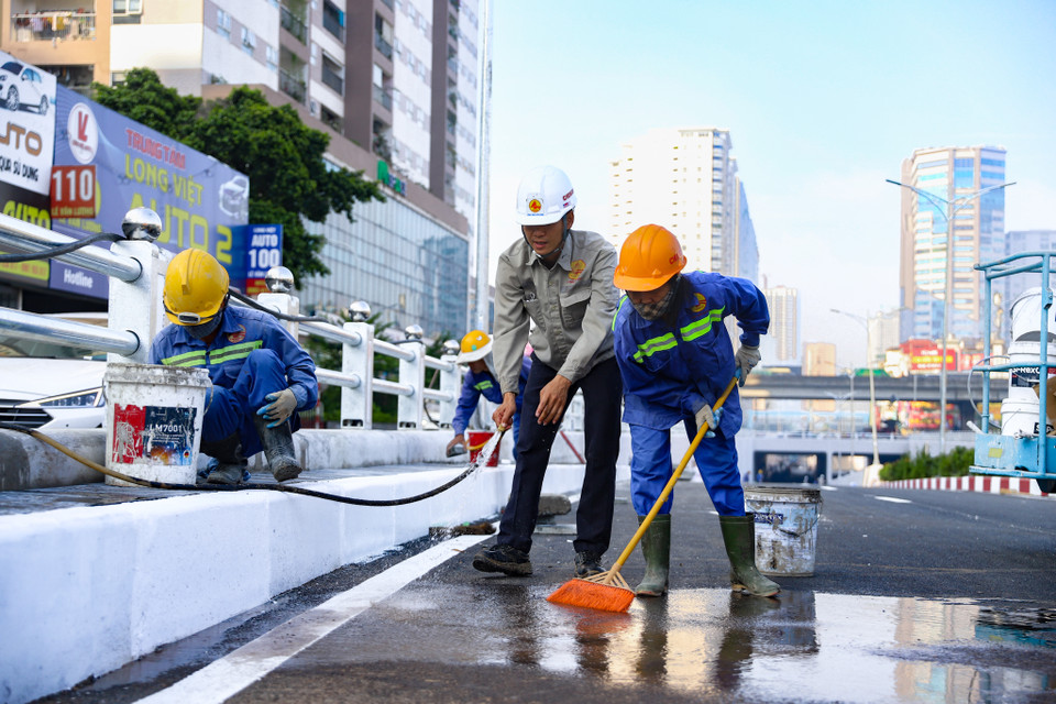 Mặt đường được dọn dẹp những ‘tàn dư’ như rác và bê tông dính dưới bề mặt và được quét, rửa lại bằng nước. (Ảnh: Hoài Nam/Vietnam+)