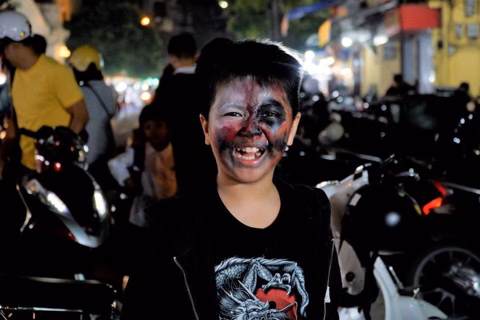 Một bé trai đang khoe chiếc mặt nạ “tự làm” của mình. (Ảnh: Minh Hiếu/Vietnam+)