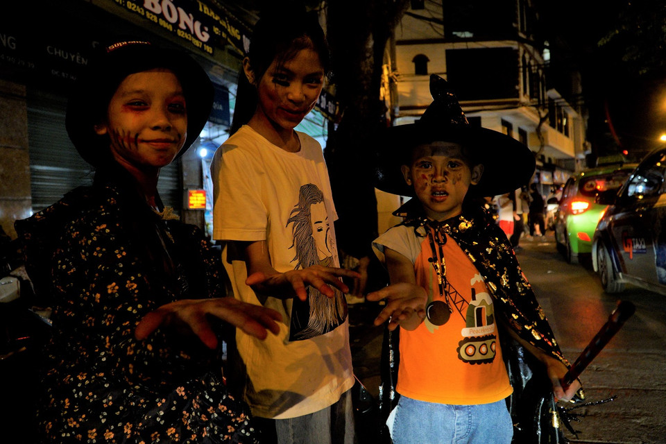 Các em bé đang xin kẹo từ người xung quanh. (Ảnh: Minh Hiếu/Vietnam+)