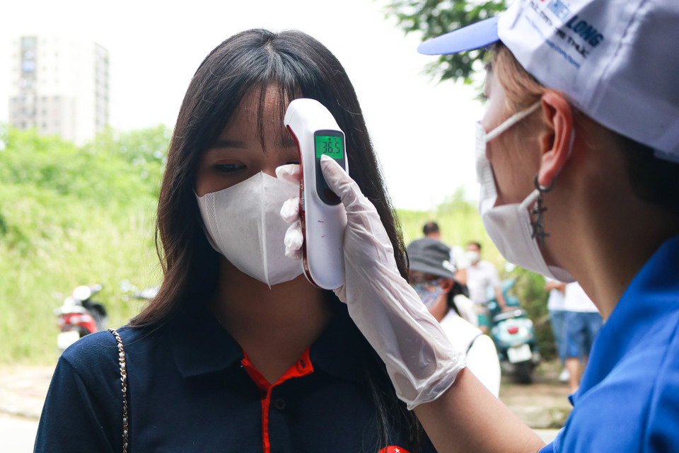 Các em học sinh bắt buộc phải đeo khẩu trang và được do thân nhiệt tại cổng của mỗi điểm thi. (Ảnh: Nguyên An/Vietnam+)