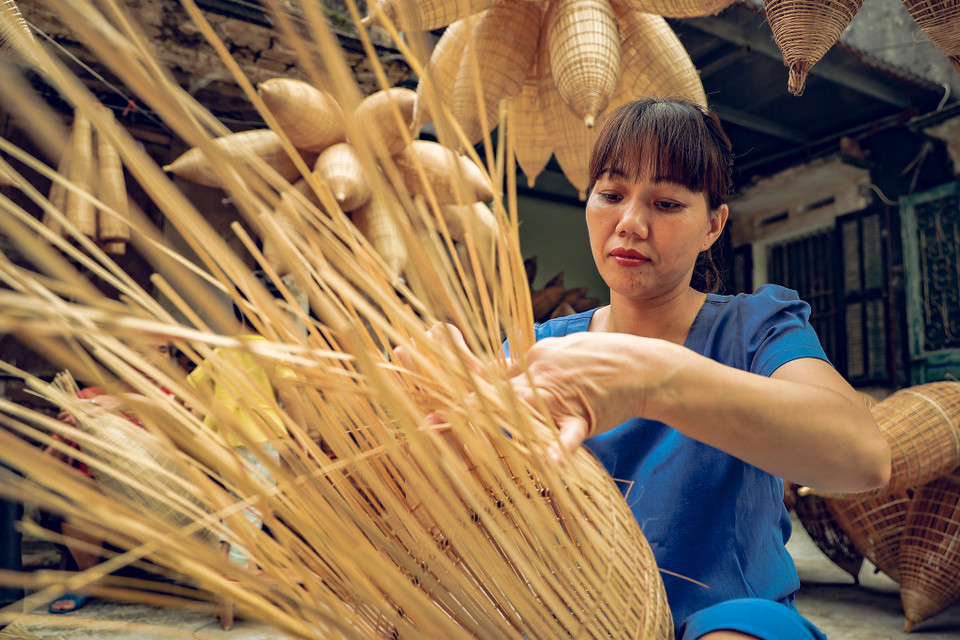 Chị Ngọt - một người dân trong làng chia sẻ thêm: 'Tranh thủ những lúc nhàn rỗi vẫn qua nhà cụ để đan đó, vừa có thêm thu nhập vừa có cơ hội giữ được tay nghề.’ (Ảnh: Hoài Nam/Vietnam+)