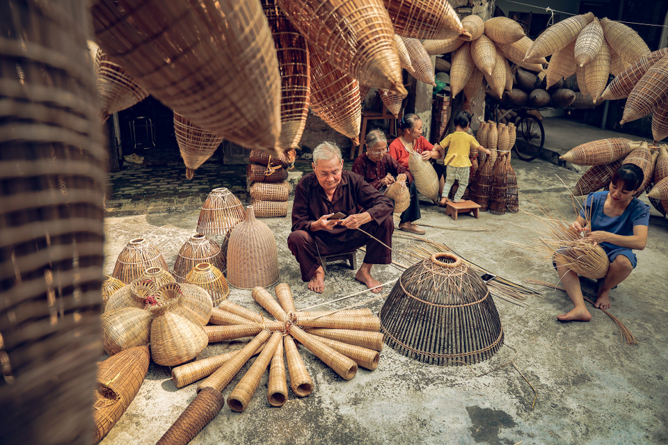 Chẳng hiểu nghề đan rọ, đó ‘thấm’ vào mỗi người dân ở đây theo cách nào mà ở Tất Viên, tất cả già, trẻ, gái, trai đều có thể đan rọ, đó. (Ảnh: Hoài Nam/Vietnam+)