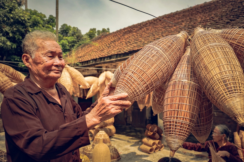 Một người thợ cứng nghề có thể đan xong một chiếc đó trong vòng 60 phút. Sau đó đem phơi ngoài nắng hoặc đem treo gác bếp hun khói để tăng độ bền cho sản phẩm. Khi đó ngả vàng sậm thì có thể xuất hàng. (Ảnh: Hoài Nam/Vietnam+)