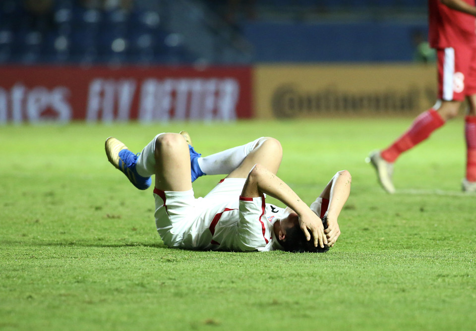 Cầu thủ U23 Triều Tiên đổ gục xuống sân ngay sau tiếng còi kết thúc trận đấu của trọng tài chính khi vừa để thua tối thiểu 1-2 trước U23 Jordan. (Ảnh: Nguyên An/Vietnam+)