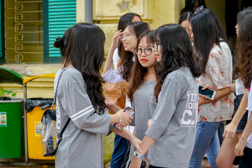 Đội tình nguyện học sinh trường THPT Việt Đức có mặt để giúp đỡ các thí sinh tìm phòng của mình. (Ảnh: Minh Hiếu/Vietnam+)