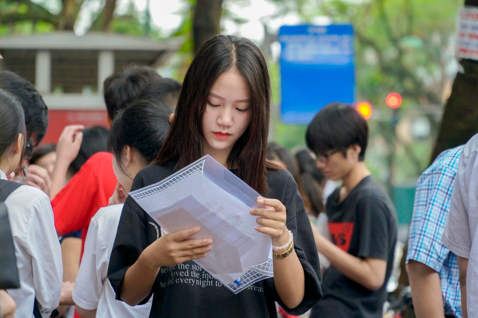 Một bạn học sinh đang kiểm tra lại giấy tờ để chuẩn bị vào nhận phòng thi. (Ảnh: Minh Hiếu/Vietnam+)