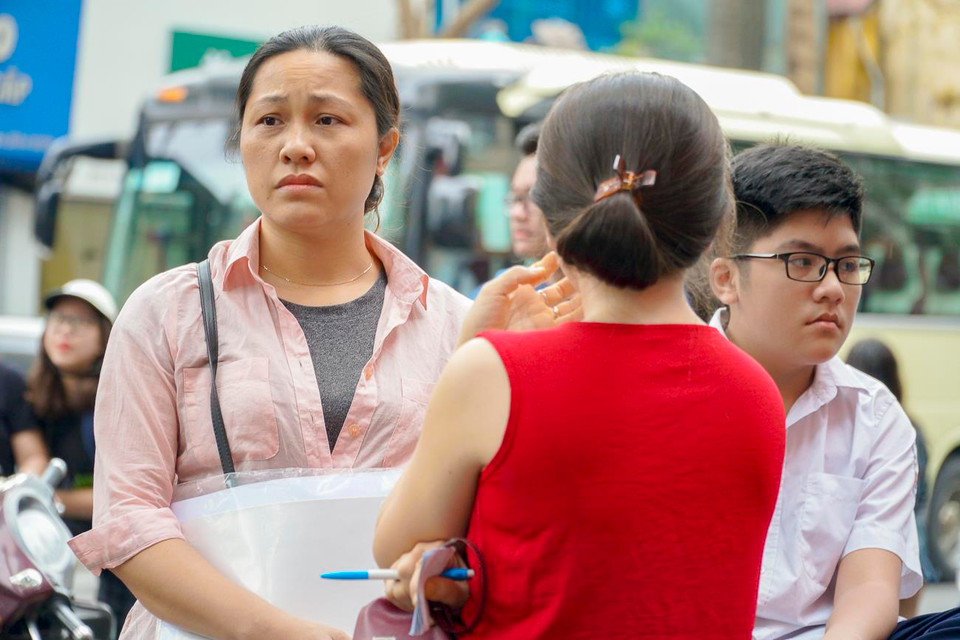 Nét mặt lo âu của một phụ huynh khi con chuẩn bị bước vào kỳ thi sắp tới. (Ảnh: Minh Hiếu/Vietnam+)