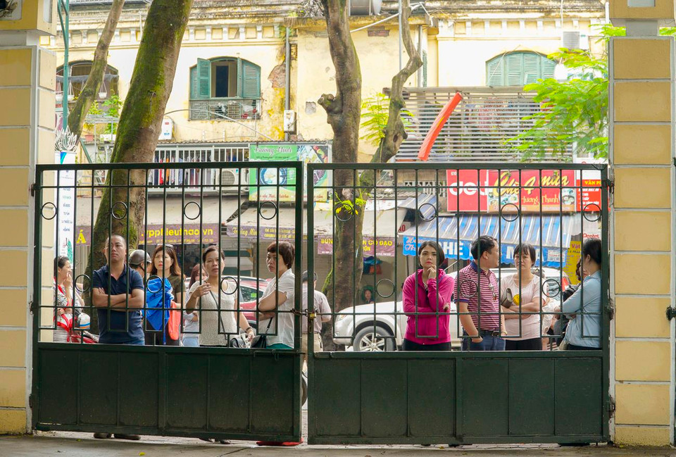 Phụ huynh đứng ngồi không yên đợi các thí sinh ở bên ngoài. (Ảnh: Minh Hiếu/Vietnam+)