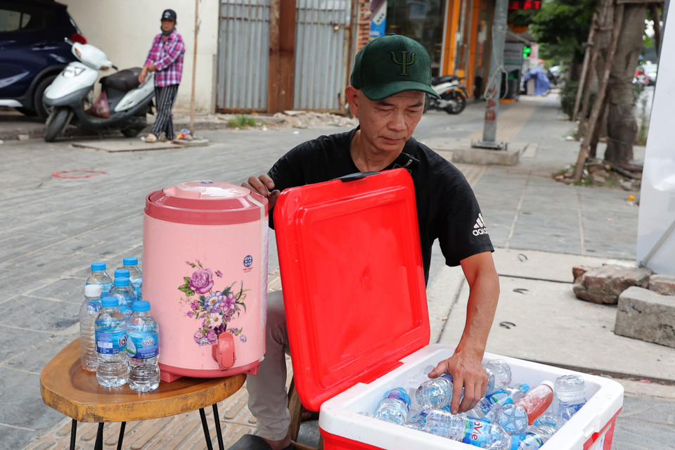 Mỗi ngày gia đình anh chuẩn bị khoảng hơn 100 chai nước miễn phí. Anh Toàn cho biết thêm nếu hôm trời nắng nóng gay gắt hơn thì sẽ chuẩn bị thêm nước để phát cả chiều. (Ảnh: Hoài Nam/Vietnam+)