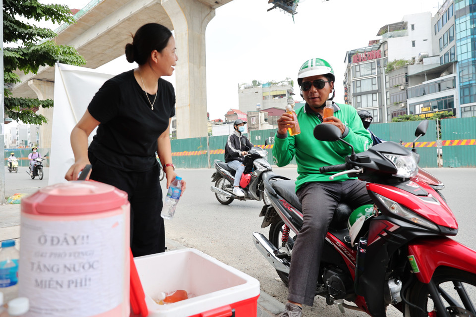 Chị Hương cho biết người đi đường có thể lấy mấy chai tùy ý nhưng có hôm chị đưa 2 chai thì người dân từ chối nói rằng nước phát miễn phí thì lấy một chai, còn để phần cho người đến sau. (Ảnh: Hoài Nam/Vietnam+)